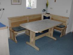 Holztisch und -eckbank mit blauen Polstern